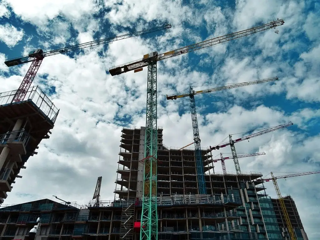 How to File a CIS Return in the UK – Complete Guide for Contractors Urban construction site with numerous cranes framing rising skyscrapers against a blue sky.